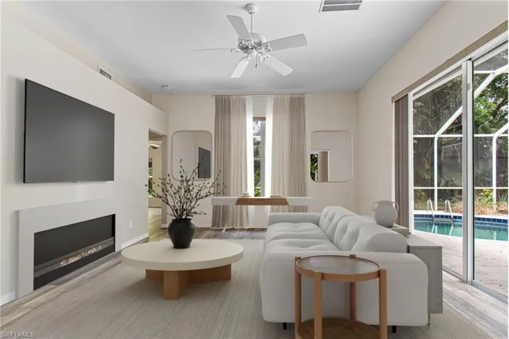 Virtually Staged Living room with new light wood-type flooring and a wealth of natural light
