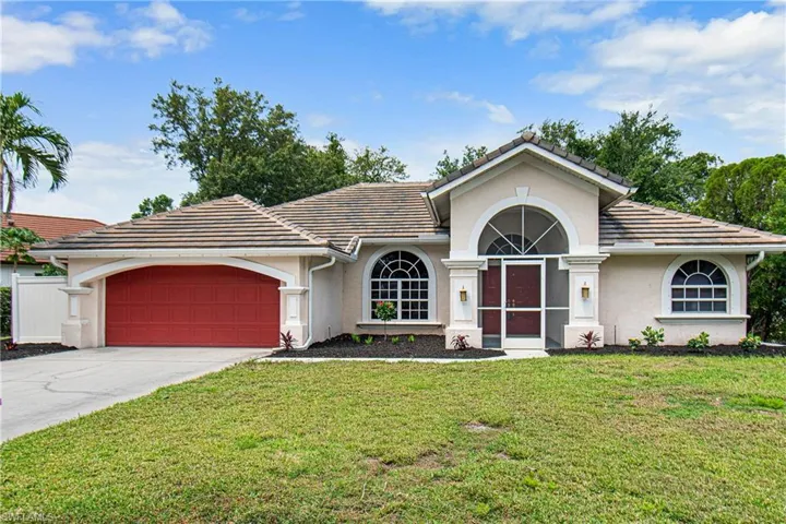 Ranch-style home with a garage and a front lawn