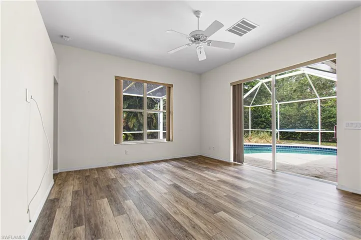 living room featuring new wood-type flooring, a healthy amount of sunlight, and ceiling fan