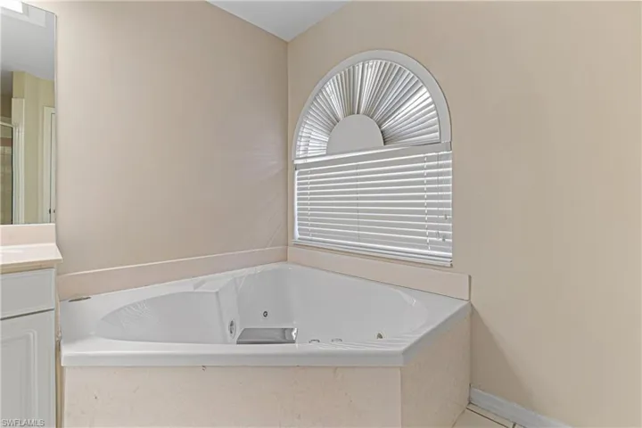 Bathroom featuring vanity and tiled tub