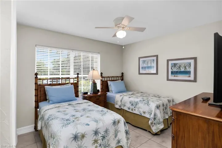 Window with horizontal blinds, ceiling fan with integrated lighting, and tile flooring and TV