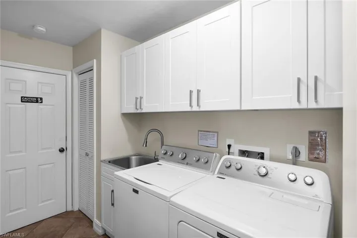 Laundry area featuring upper cabinetry, a utility sink