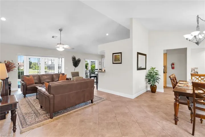 Vaulted ceilings with recessed lighting, tile flooring, and a ceiling fan in the living area