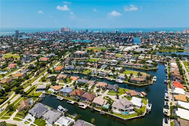 Coastal community featuring canal access, residential properties, and distant urban skyline