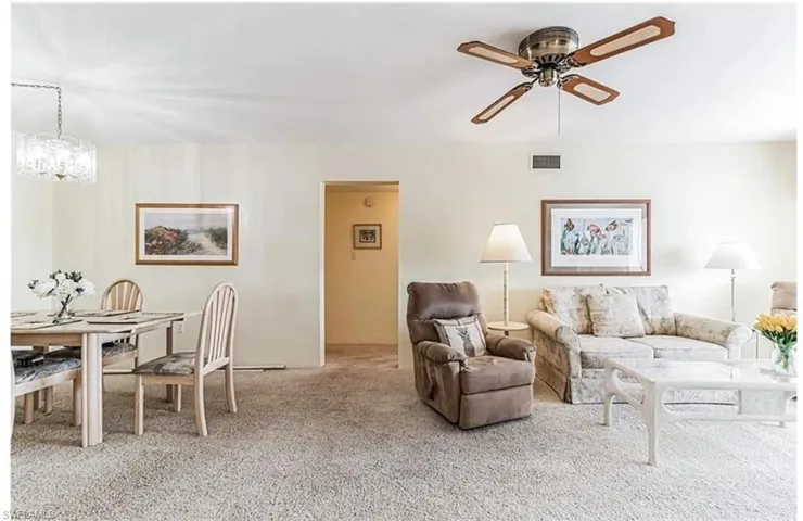 Living room with ceiling fan and carpet