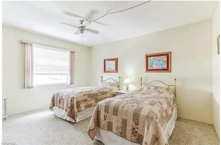 Carpeted bedroom featuring ceiling fan