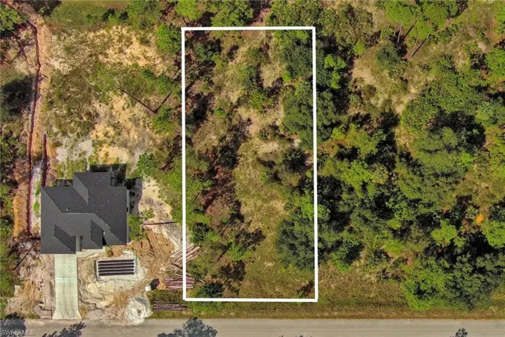 Aerial view of property and surrounding area with property parcel outlined