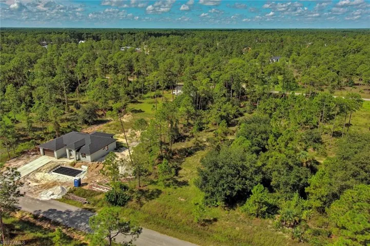Aerial view of property and surrounding area featuring a heavily wooded area