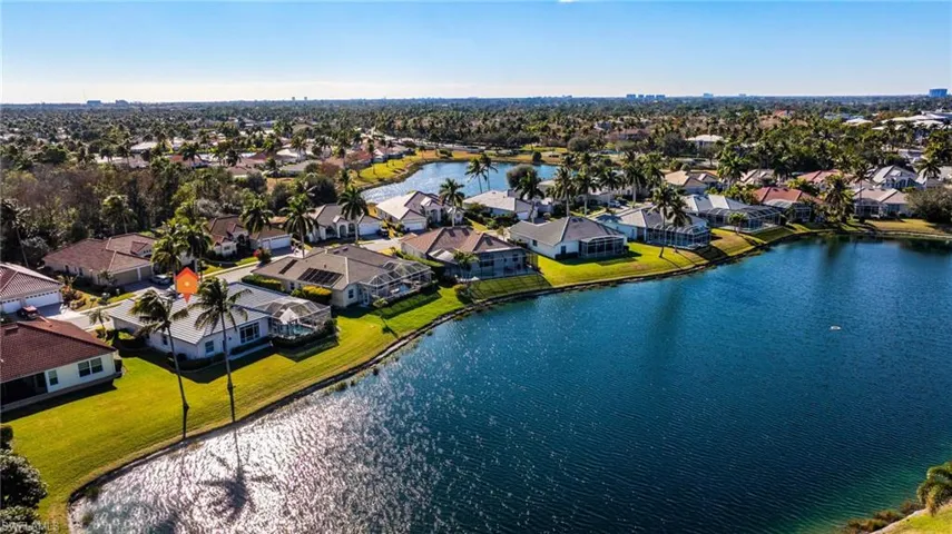 Aerial view of property's location featuring a nearby body of water and nearby suburban area