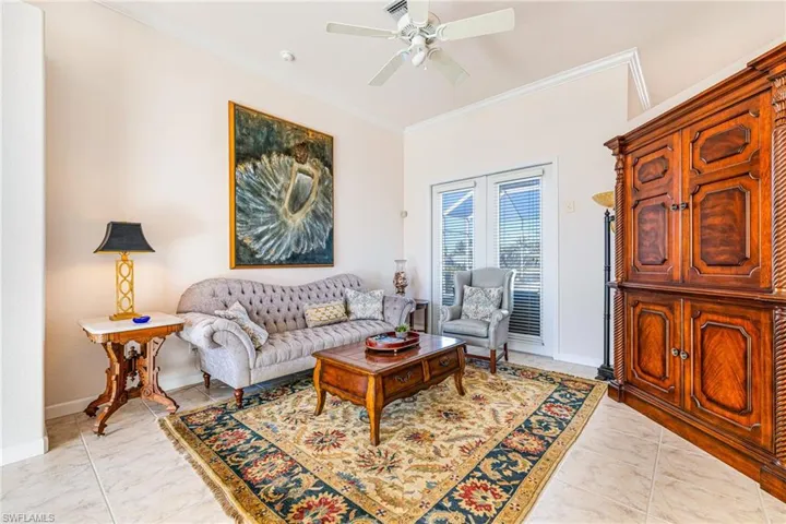 Living room featuring crown molding and a ceiling fan