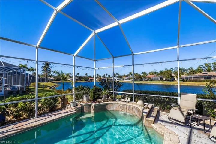 Swimming pool featuring a sunroom, glass enclosure, and a water view