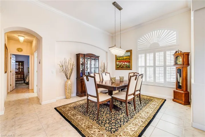 Dining space with arched walkways and ornamental molding