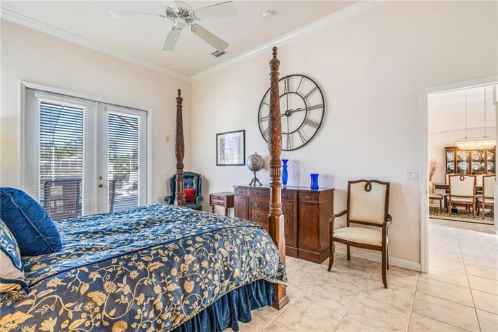Bedroom with ornamental molding, access to outside, french doors, a ceiling fan, and light tile patterned flooring