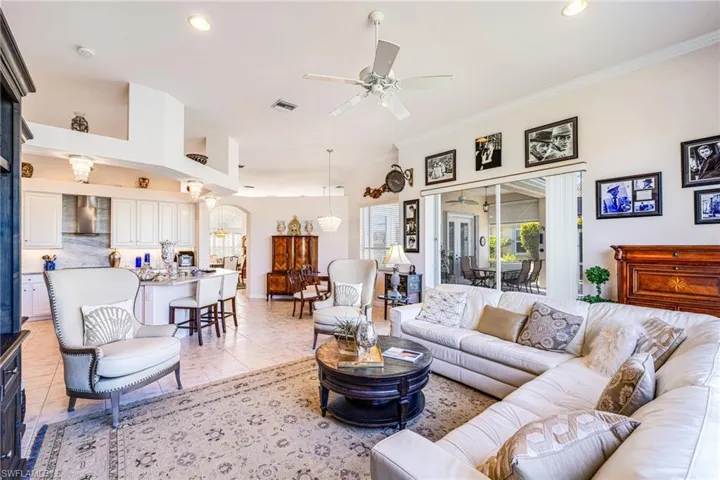 Living area featuring a ceiling fan, healthy amount of natural light, recessed lighting, and ornamental molding