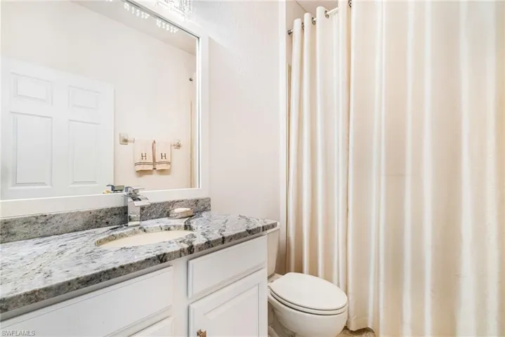 Full bath with curtained shower and vanity