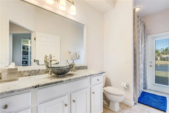 Full bathroom with curtained shower and vanity