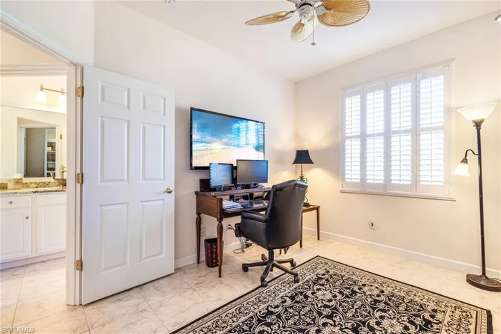 Home office featuring ceiling fan and light marble finish flooring