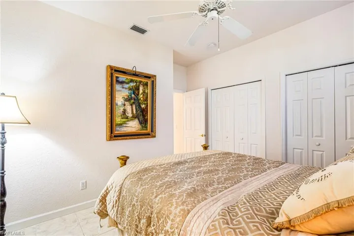 Bedroom with multiple closets and ceiling fan