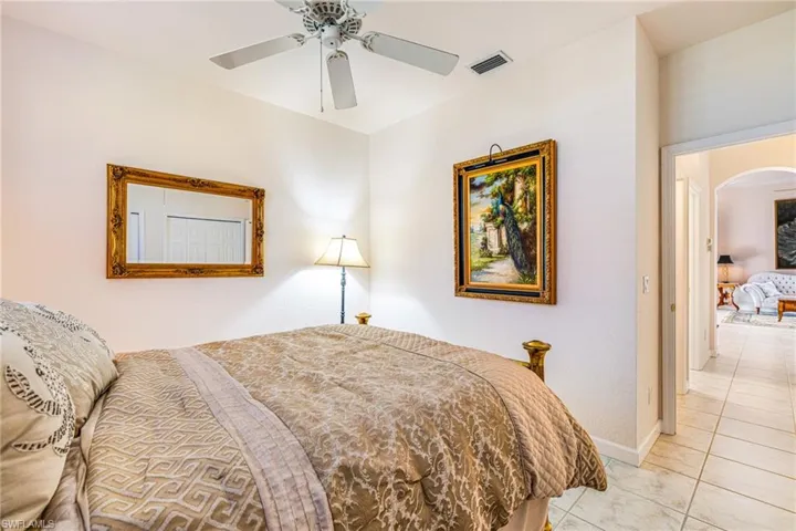 Bedroom with arched walkways and ceiling fan