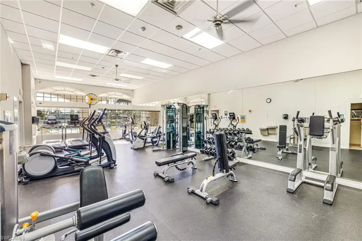 Gym with a high drop ceiling and a ceiling fan