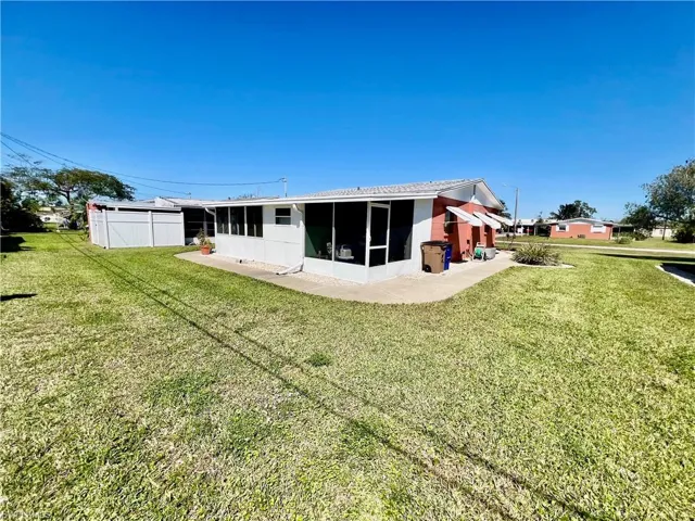 Back of house featuring a yard and a screened lanai.