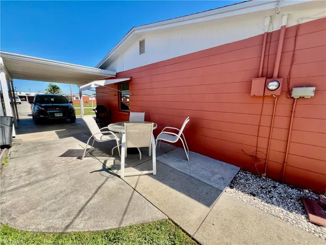 View of patio with a carport, driveway, and outdoor dining area