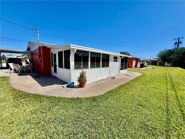 Rear view of property featuring a yard and a patio area