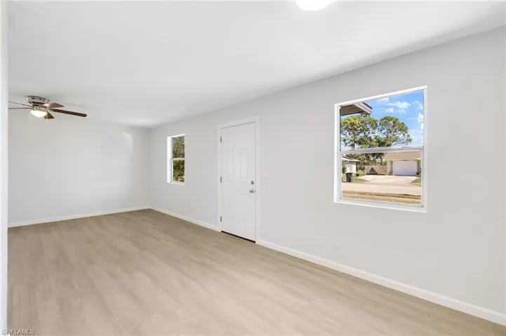 Unfurnished room featuring plenty of natural light, ceiling fan, and light hardwood / wood-style flooring