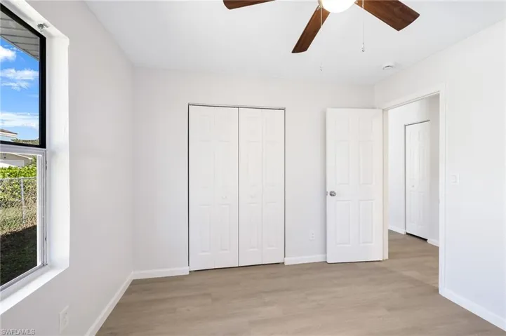 Unfurnished bedroom featuring ceiling fan, light hardwood / wood-style floors, and a closet