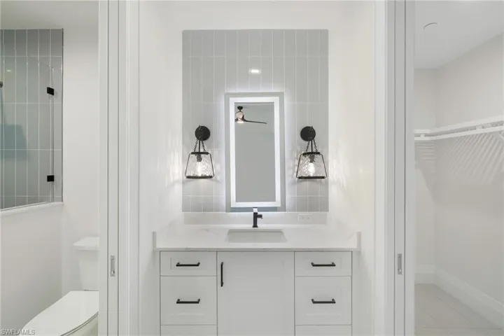 Vanity with a stone countertop, an integrated sink, and matte black hardware