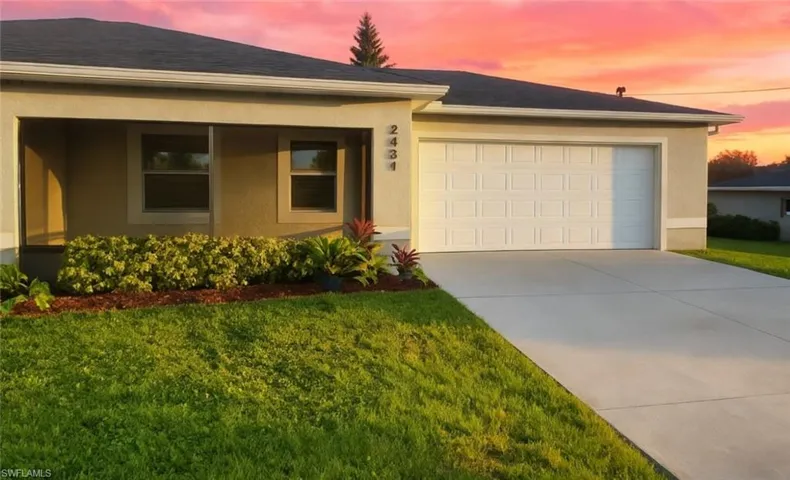 Ranch-style home featuring stucco siding, concrete driveway, a garage, and a front lawn