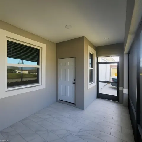 Doorway to property featuring a sunroom and stucco siding