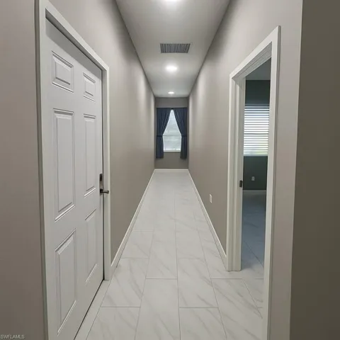 Corridor featuring baseboards and light marble finish flooring