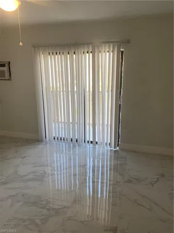 Unfurnished room featuring an AC wall unit