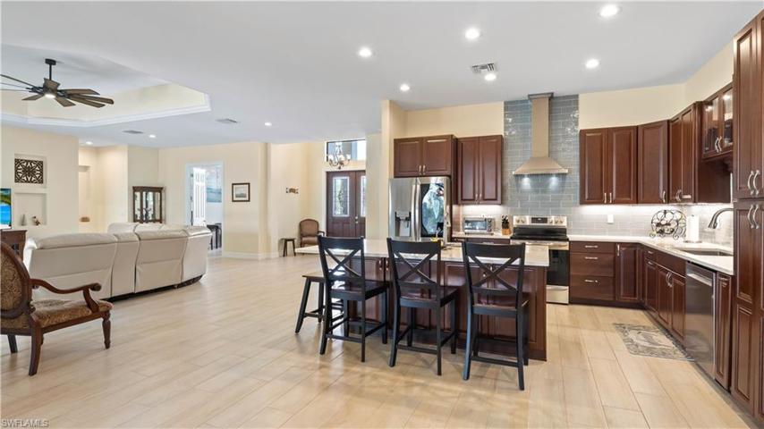 View from kitchen towards the front door, office and great room!  Additional sink on the kitchen island is great for prepping for entertaining and there is tons of counter space for buffet style serving!