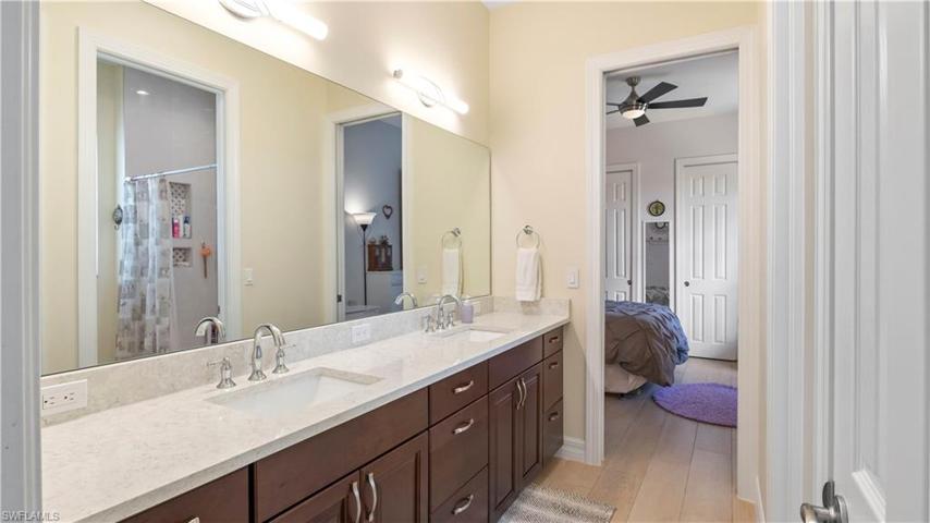 Jack and Jill bath between the two guest rooms with dual vanities, wall to wall mirrors and lots of cabinet space.  Bath and shower combo with tile niches and private water closet!