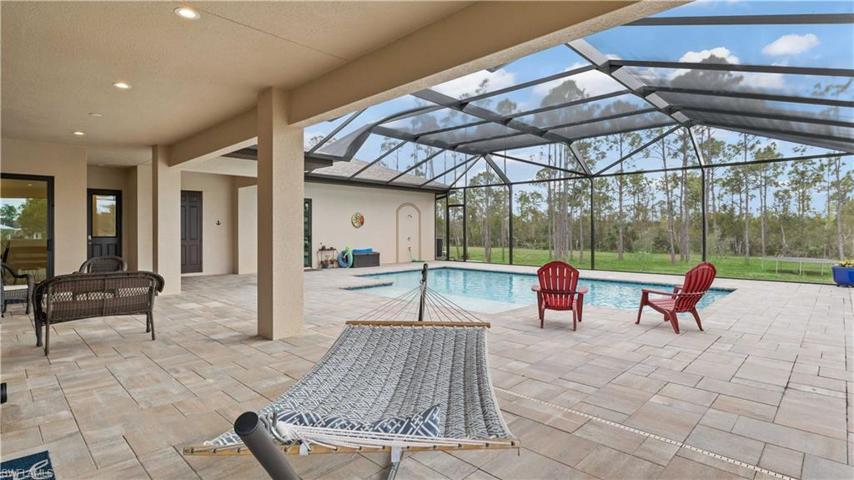 Looking south towards the tree line from underneath the shaded lanai.  Ceiling is stuccoed and as throughout the entire home, there is a two foot overhang with 2" by 10" fascia boards and recessed 6" LED can lighting.