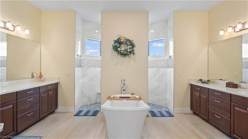 Double his and hers vanities - quartz countertops, garden tub and large dual entry walk in shower.  Custom tilework really adds a serene vibe to the bathroom!