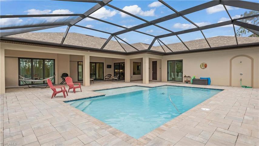 Extensive covered patio areas that are shaded and perfect for large outdoor furniture including multiple sets of dining / outdoor living furniture arrangements.  Double slider door to the right is the guest home area and there are two sets of triple disappearing sliders - the great room and the master bedroom.  Best part of living in SWFL is the outdoor living space which is easily combined and extended with the inside once the sliders are open!
