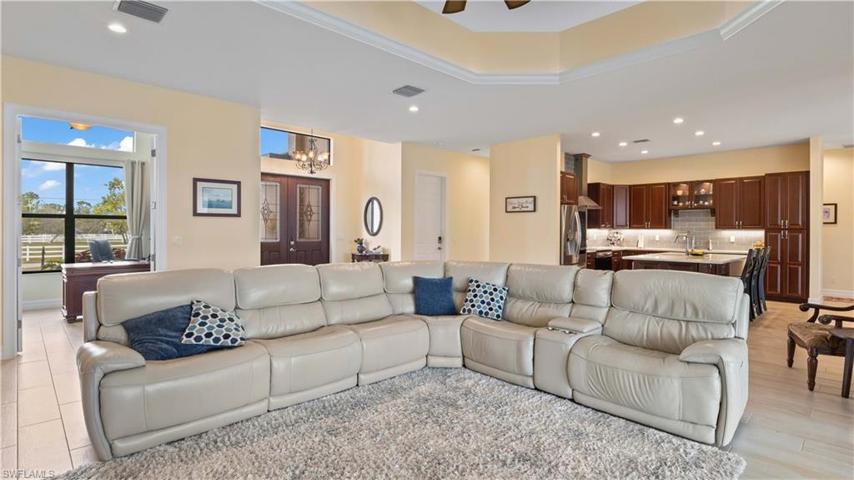 Great room is the heart of the home and can easily large furniture layouts!  In ground electrical outlet, 2 foot tray lgihted ceiling, triple sliders to the outside - a perfect layout!