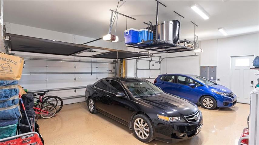 Three car garage with epoxy flooring, 50 amp outlets for generator back feed, tons of overhead storage and a VERY LARGE attic with room to stand up easily and reinforced for storage.  Garage doors are insulated and Lifestyle screen installed on 16'x 8' door.  Side exit door and additional parking in the metal building for all your overflow garage needs.