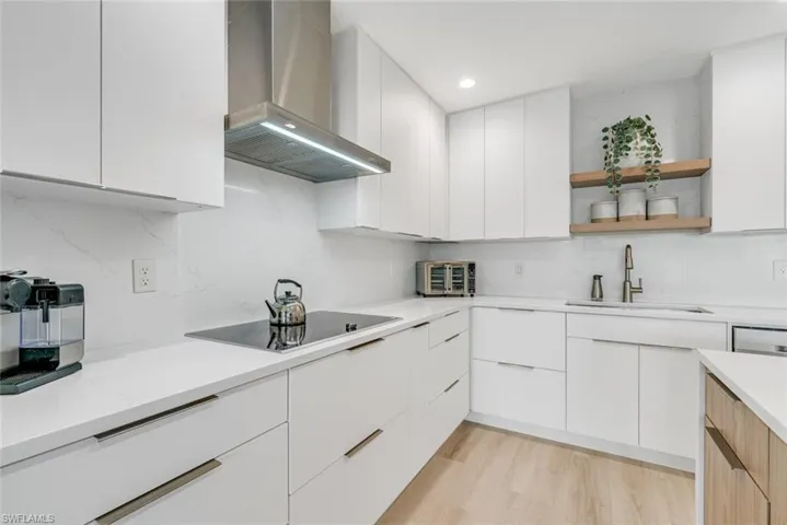 Kitchen featuring white cabinets, modern cabinets, wall chimney exhaust hood, and open shelves