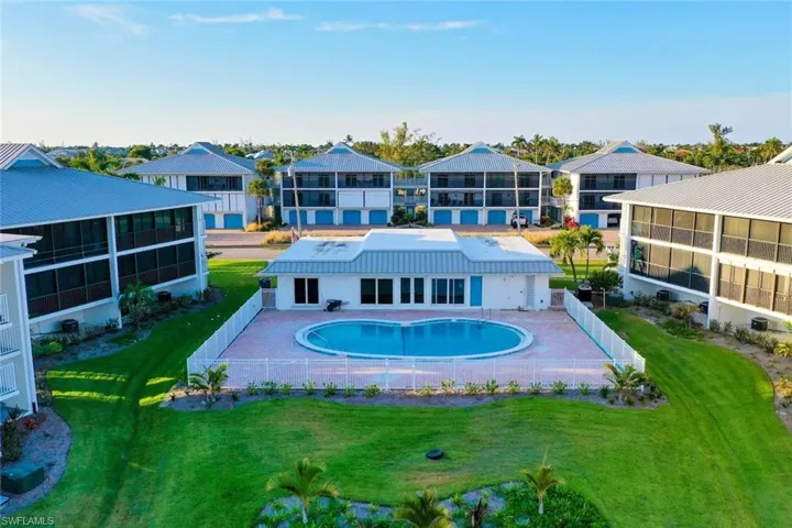Community pool with a fenced backyard and a patio area