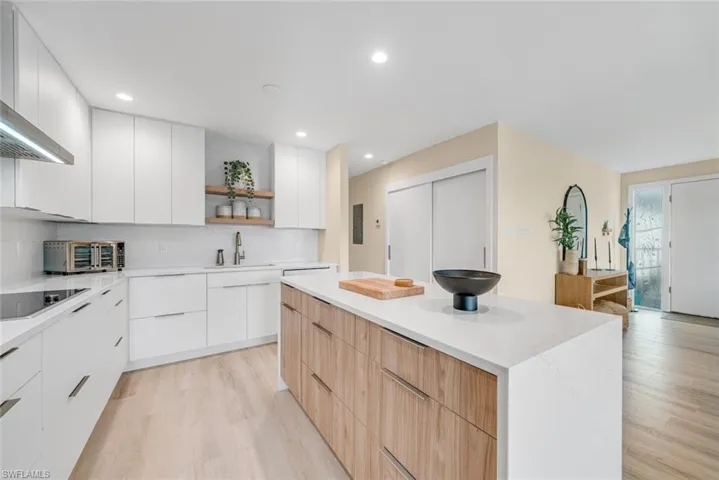 Kitchen featuring open shelves, light brown cabinetry, white cabinetry, modern cabinets, and backsplash