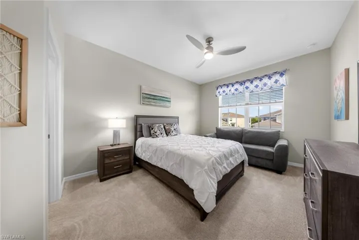 Bedroom featuring a ceiling fan and light colored carpet