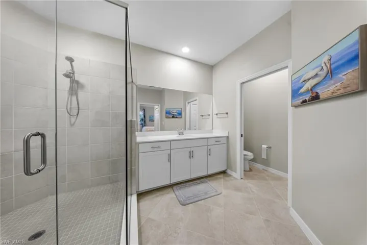 Bathroom with vanity, a stall shower, and light tile patterned floors