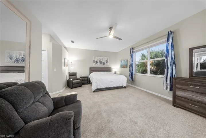 Bedroom with light carpet and a ceiling fan