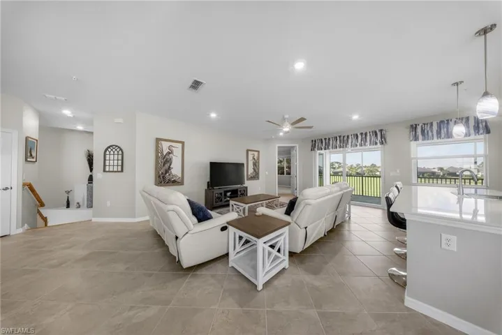 Living area with a ceiling fan, recessed lighting, and light tile patterned flooring