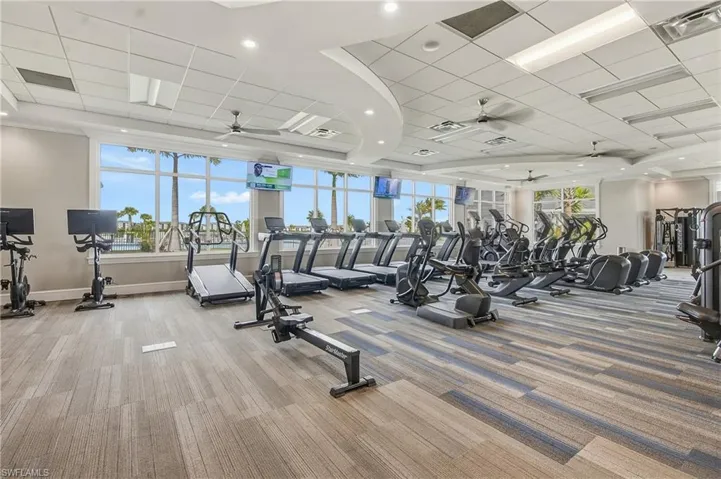 Gym with ceiling fan and a drop ceiling