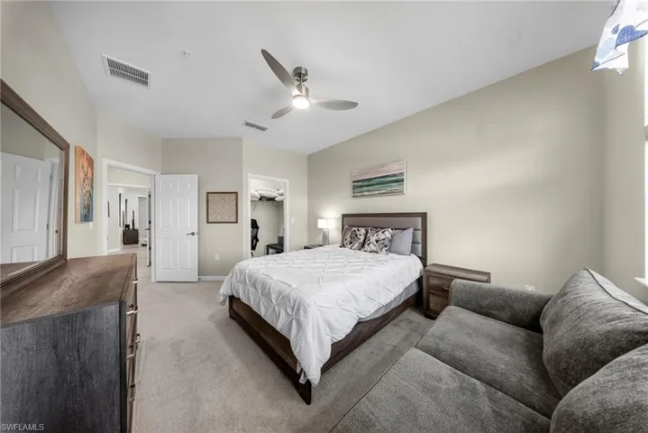 Bedroom with a spacious closet, carpet flooring, and ceiling fan